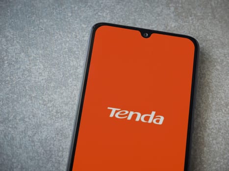 Lod, Israel - July 16,2023: Tenda Wifi app launch screen on smartphone on ceramic stone background. Top view flat lay with copy space.