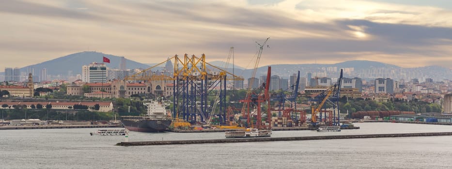 Istanbul, Turkey - May 11, 2023: Beautiful sunrise over Haydarpasa Port, with cargo ships and cranes silhouetted against the sky. Water reflects the colors of the sunrise, View from Topkapi Palace