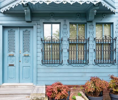 Charming blue house with wooden decorated door and ornate wrought iron windows. The house is located at an alley suited in Kuzguncuk neighborhood, Uskudar district, Istanbul, Turkey