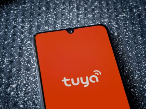 Lod, Israel - July 16,2023: Tuya Smart app launch screen on smartphone on metallic background. Close up top view flat lay.