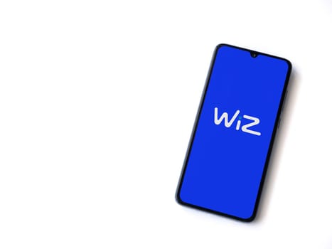 Lod, Israel - July 16,2023: WIZ app launch screen on smartphone on white background. Top view flat lay with copy space.