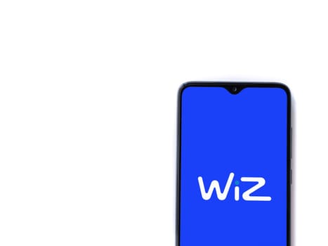 Lod, Israel - July 16,2023: WIZ app launch screen on smartphone on white background. Top view flat lay with copy space.