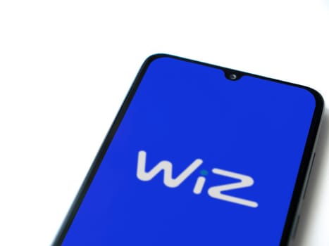 Lod, Israel - July 16,2023: WIZ app launch screen on smartphone on white background. Top view flat lay with copy space.