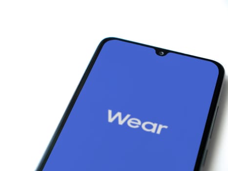 Lod, Israel - July 16,2023: Wear - Galaxy Wearable app launch screen on smartphone on white background. Top view flat lay with copy space.