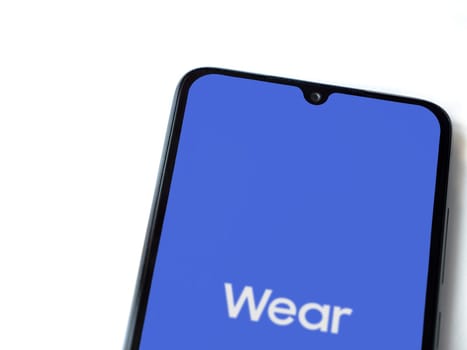 Lod, Israel - July 16,2023: Wear - Galaxy Wearable app launch screen on smartphone on white background. Top view flat lay with copy space.