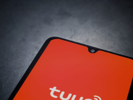 Lod, Israel - July 16,2023: Tuya Smart app launch screen on smartphone on dark marble stone background. Top view flat lay with copy space.