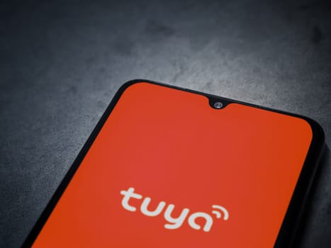 Lod, Israel - July 16,2023: Tuya Smart app launch screen on smartphone on dark marble stone background. Top view flat lay with copy space.