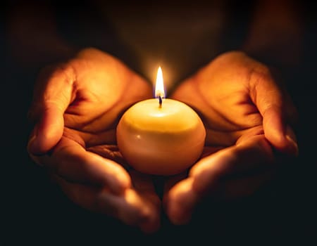 small candle burning held in hands on black background generative ai