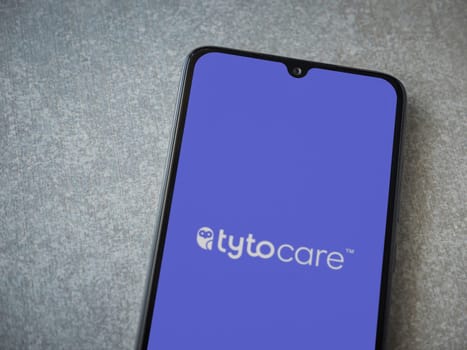 Lod, Israel - July 16,2023: TytoCare app launch screen on smartphone on ceramic stone background. Top view flat lay with copy space.