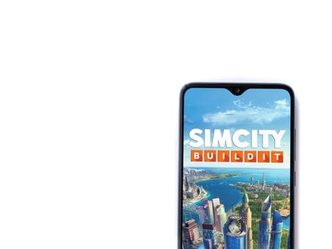 Lod, Israel - July 16,2023: SimCity BuildIt app launch screen on smartphone on white background. Top view flat lay with copy space.
