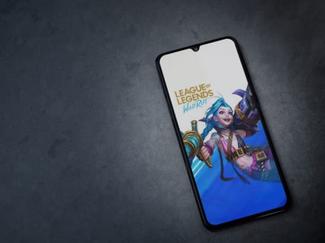 Lod, Israel - July 16,2023: League of Legends - Wild Rift app launch screen on smartphone on dark marble stone background. Top view flat lay with copy space.