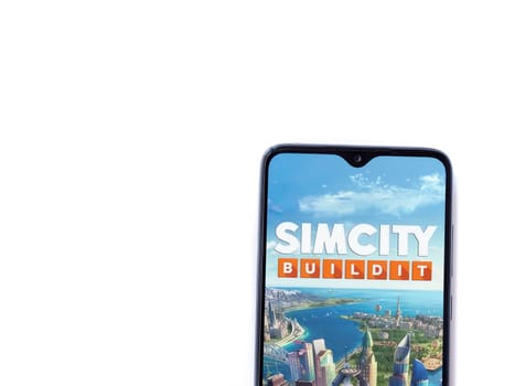 Lod, Israel - July 16,2023: SimCity BuildIt app launch screen on smartphone on white background. Top view flat lay with copy space.