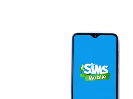 Lod, Israel - July 16,2023: The Sims Mobile app launch screen on smartphone on white background. Top view flat lay with copy space.