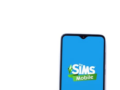 Lod, Israel - July 16,2023: The Sims Mobile app launch screen on smartphone on white background. Top view flat lay with copy space.