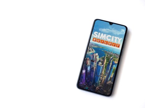Lod, Israel - July 16,2023: SimCity BuildIt app launch screen on smartphone on white background. Top view flat lay with copy space.