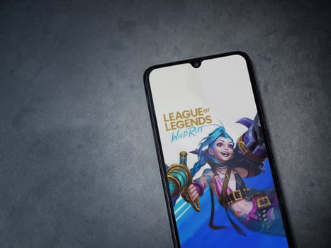 Lod, Israel - July 16,2023: League of Legends - Wild Rift app launch screen on smartphone on dark marble stone background. Top view flat lay with copy space.