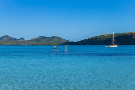 Nacula, Fiji: 26 May 2023: happy couple enjoying stand up paddling during summer vacation. Nacula Island, Fiji