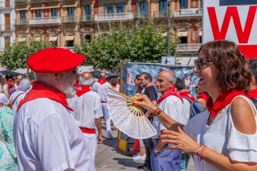 Pamplona, Spain: 09 July 2023: People celebrate San Fermin festival in traditional white abd red clothing with red necktie, Pamplona, Navarra, Spain.