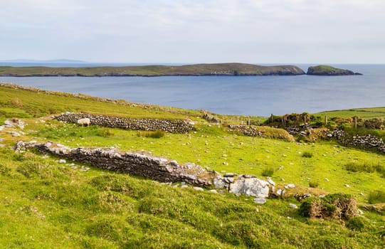Green hills on the Atlantic Ocean on a sunny spring day. Blue sky over the sea coast. The coastline of Ireland, West Cork.