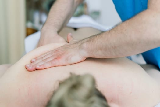 Young fat woman getting massage treatment in a day spa cabinet.