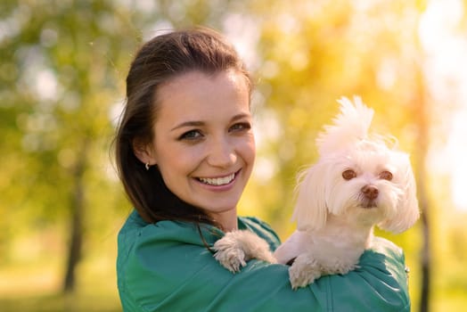 Young girl with her dog. Puppy white dog is running with it's owner. Conception about friendship, animal and freedom.