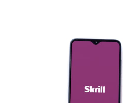 Lod, Israel - July 16,2023: Skrill app launch screen on smartphone on white background. Top view flat lay with copy space.