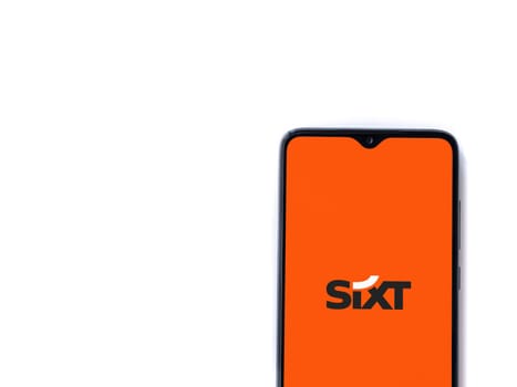 Lod, Israel - July 16,2023: SIXT rent app launch screen on smartphone on white background. Top view flat lay with copy space.