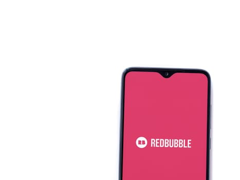 Lod, Israel - July 16,2023: Redbubble app launch screen on smartphone on white background. Top view flat lay with copy space.