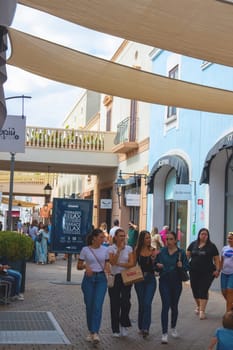 Sicily, Italy, Agira - 30 Sep 2023. Sicilia Outlet Village shopping centre is a popular visitor magnet. Passage with people where shopping at Outlet Village.