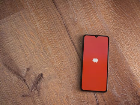 Lod, Israel - July 16,2023: Money Manager Expense & Budget app launch screen on smartphone on wooden background. Top view flat lay with copy space.