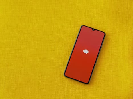 Lod, Israel - July 16,2023: Money Manager Expense & Budget app launch screen on smartphone on yellow fabric background. Top view flat lay with copy space.