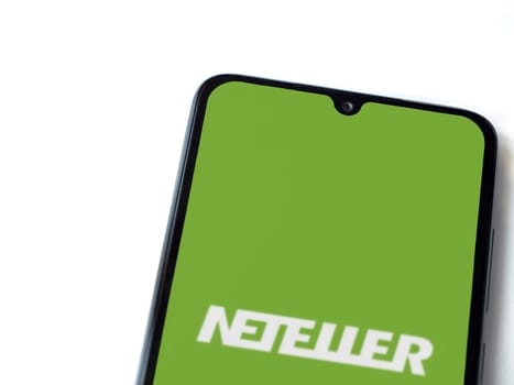 Lod, Israel - July 16,2023: NETELLER app launch screen on smartphone on white background. Top view flat lay with copy space.
