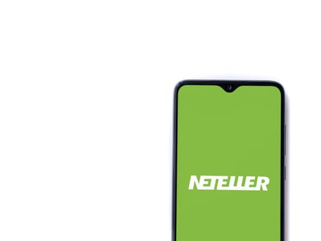 Lod, Israel - July 16,2023: NETELLER app launch screen on smartphone on white background. Top view flat lay with copy space.