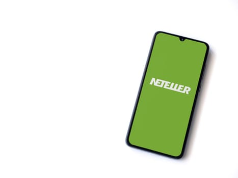 Lod, Israel - July 16,2023: NETELLER app launch screen on smartphone on white background. Top view flat lay with copy space.