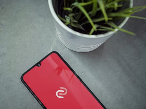 Lod, Israel - July 16,2023: Modern workspace with smartphone with Twilio Authy Authenticator app launch screen on marble background. Close up top view flat lay.
