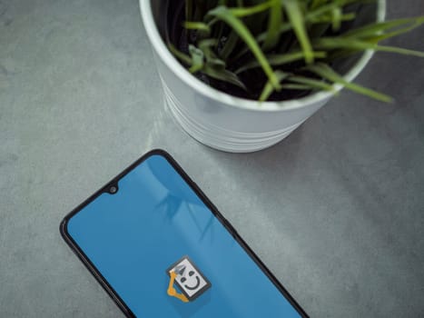 Lod, Israel - July 16,2023: Modern workspace with smartphone with Automate app launch screen on marble background. Close up top view flat lay.