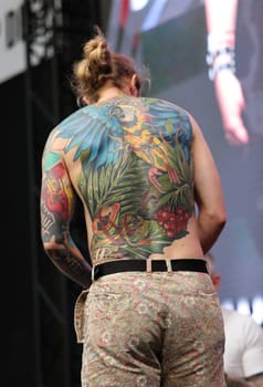 Krakow, Poland - June 11, 2022: Unidentified participant during the contest for the best tattoo at the 15th Tattoofest Convention in Cracow. One of the most prestigious tattoo festivals.