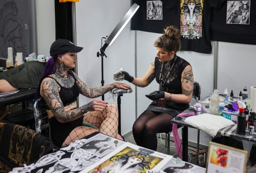 Krakow, Poland -  June 12, 2022: Unidentified  participant at 15th Tattoofest Convention in Cracow. Tattoo artist at work.