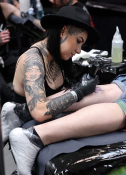 Krakow, Poland -  June 12, 2022: Unidentified  participant at 15th Tattoofest Convention in Cracow. Tattoo artist at work.