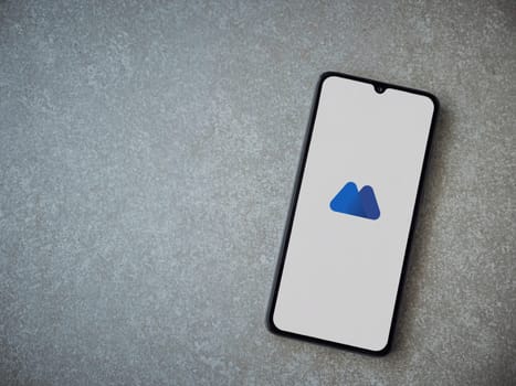 Lod, Israel - July 16,2023: MEXC app launch screen on smartphone on ceramic stone background. Top view flat lay with copy space.