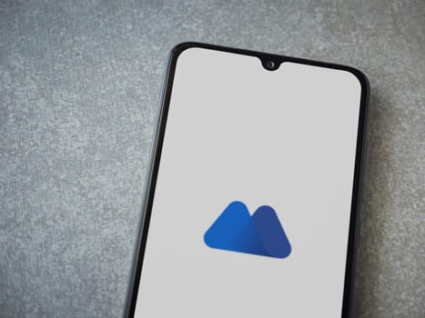 Lod, Israel - July 16,2023: MEXC app launch screen on smartphone on ceramic stone background. Top view flat lay with copy space.
