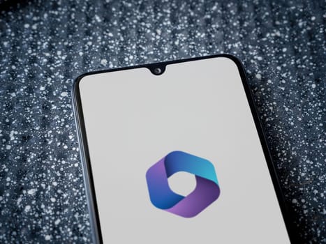 Lod, Israel - July 16,2023: Microsoft 360 app launch screen on smartphone on metallic background. Close up top view flat lay.