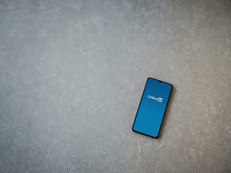 Lod, Israel - July 16,2023: LinkedIn app launch screen on smartphone on ceramic stone background. Top view flat lay with copy space.