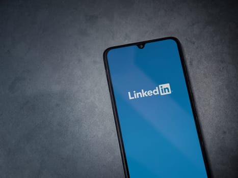 Lod, Israel - July 16,2023: LinkedIn app launch screen on smartphone on dark marble stone background. Top view flat lay with copy space.