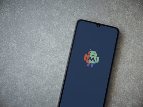 Lod, Israel - July 16,2023: MacroDroid app launch screen on smartphone on ceramic stone background. Top view flat lay with copy space.