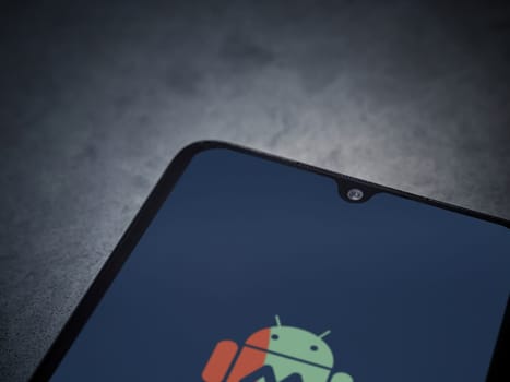 Lod, Israel - July 16,2023: MacroDroid app launch screen on smartphone on dark marble stone background. Top view flat lay with copy space.
