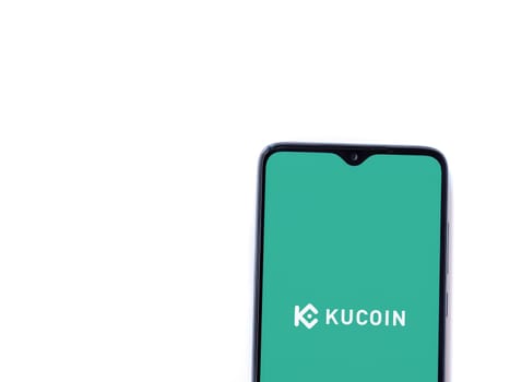 Lod, Israel - July 16,2023: KuCoin app launch screen on smartphone on white background. Top view flat lay with copy space.