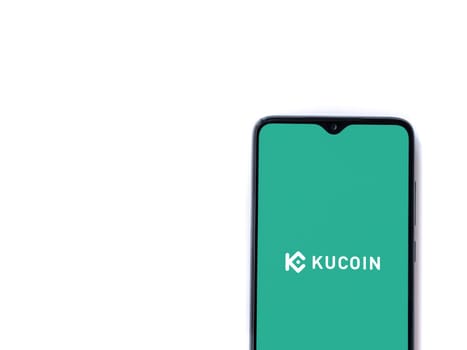 Lod, Israel - July 16,2023: KuCoin app launch screen on smartphone on white background. Top view flat lay with copy space.