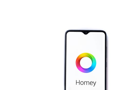 Lod, Israel - July 16,2023: Homey app launch screen on smartphone on white background. Top view flat lay with copy space.