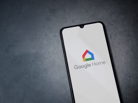 Lod, Israel - July 16,2023: Google Home app launch screen on smartphone on dark marble stone background. Top view flat lay with copy space.